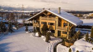 une maison avec un toit enneigé dans la neige dans l'établissement Villa Chalet Everest, à Bansko