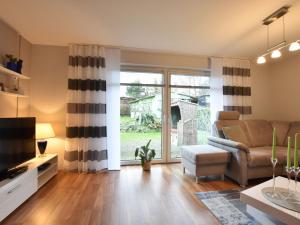 a living room with a couch and a television at Cozy Holiday Home in Hohenkirchen near Baltic Sea in Hohenkirchen