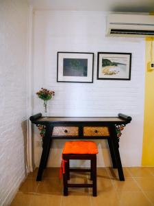 a desk with a chair and a vase of flowers at Moradok Thai Guesthouse in Phra Nakhon Si Ayutthaya