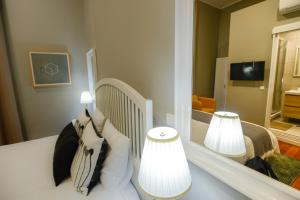 a bed room with a lamp and a mirror at Casa Conforto in Ponta Delgada