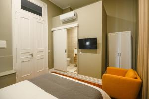 ポンタ・デルガダにあるCasa Confortoのベッドルーム1室(ベッド1台、椅子、鏡付)