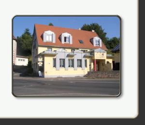 une grande maison jaune avec un toit rouge dans l'établissement LandGASTHOF Rose, à Dammbach