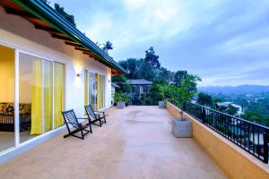 a balcony with chairs and a view of the mountains at Feel Home in Kandy