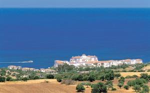 a large house on top of a hill next to the ocean at Anassa in Polis Chrysochous