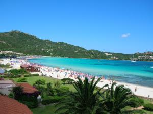 un gruppo di persone su una spiaggia con l'oceano di Marinella, Sardegna a Marinella