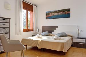 zwei Betten in einem weißen Zimmer mit Aermottermott in der Unterkunft Angela in Tamariu