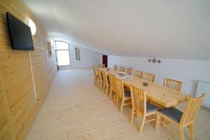 a dining room with a long wooden table and chairs at Casa Ralucăi in Moisei
