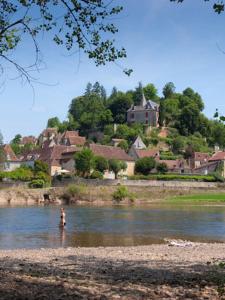 a person standing in the water in a river at Country Camp Camping Le Clou in Meynard