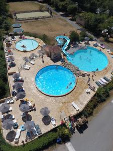 una vista aérea de 2 piscinas con sombrillas en Country Camp Camping Le Clou, en Meynard