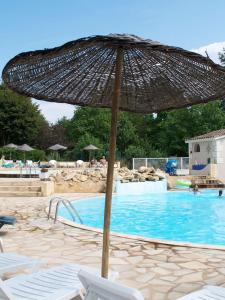 un parasol installé en face d'une piscine dans l'établissement Europe tents Camping Le Clou, à Meynard