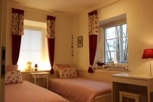 1 dormitorio con 2 camas individuales y ventana en Haus Sonnbichel am Kochelsee en Schlehdorf