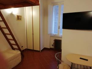 a room with a bed and a table and a television at Appartamento Zafferano in Città della Pieve