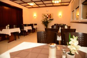 Hotel Linde Stuttgart في شتوتغارت: غرفة طعام مع طاولات وكراسي في مطعم