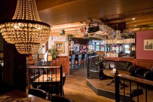 ein Restaurant mit Kronleuchter und einer Bar in der Unterkunft Hotel Verhoeven in Uden