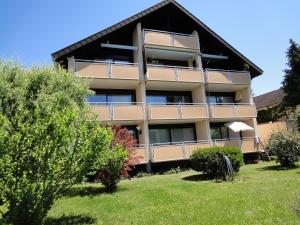 ein Gebäude mit Balkonen und Bäumen davor in der Unterkunft Annes Ferienwohnung Freiburg in Vörstetten