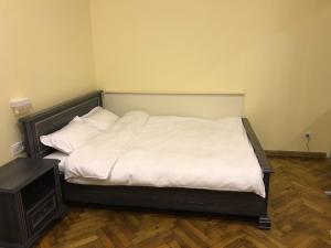 een bed met witte lakens en kussens in een kamer bij Apartment on Khorvatska Street in Lviv