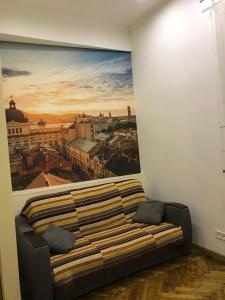 een bank in een kamer met een schilderij aan de muur bij Apartment on Khorvatska Street in Lviv