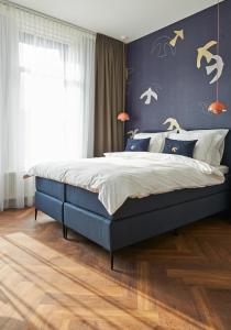 a bedroom with a blue bed and a blue wall at Hotel Pistache Den Haag in The Hague