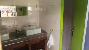 y baño con lavabo blanco y espejo. en Aux Yourtes de La Fabrique, en Saint-Florent-des-Bois