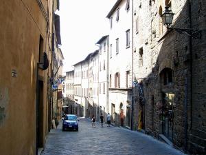 a car is driving down a street in an alley at Ricciarelli Home in Volterra