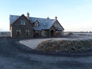 a house sitting in the middle of a field at Bealaha House in Doonbeg