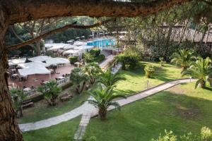 eine Aussicht über das Resort mit Tischen und Sonnenschirmen in der Unterkunft Park Hotel Marinetta - Beach & Spa in Marina di Bibbona
