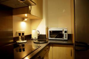a small kitchen with a microwave on a counter at Newly refurbished 1 bed first floor apartment with wifi in Cosham