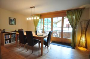 a dining room with a table and chairs and a window at Luxury Family Apartment in Lauterbrunnen