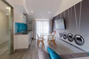 ポルトノボにあるLofts Complejo Playa Marのテーブルと椅子のあるキッチンとダイニングルーム