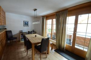 eine Küche und ein Esszimmer mit einem Holztisch und Stühlen in der Unterkunft Luxury Family Apartment in Lauterbrunnen