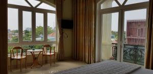 a bedroom with a bed and a table and chairs at Hai Dang Hotel in Ho Chi Minh City