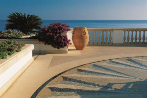 a large vase sitting on a balcony overlooking the ocean at Anassa in Polis Chrysochous