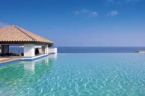 a swimming pool in the middle of the ocean at Anassa in Polis Chrysochous