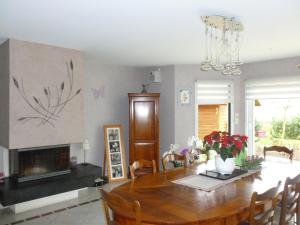 a dining room with a table and a fireplace at Jardin du Levant in Combourg