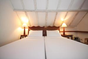 a bedroom with a large bed with two lamps at Sala Prabang Hotel in Luang Prabang