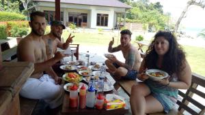 a group of people sitting around a table eating food at Panorama Seulako in Sabong