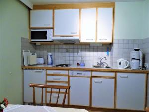 una cocina con armarios blancos y fregadero en Appartement Sylvester, en Matrei in Osttirol