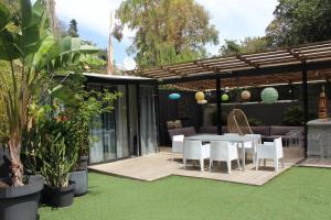a patio with a table and chairs in a garden at Villa Le Ruisseau in Cannes