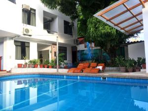 a swimming pool with orange chairs and a building at Hotel Cielo Tarapoto in Tarapoto