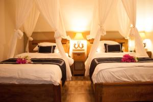 a bedroom with two beds with flowers on them at Casa Narrow Villa in Nembrala