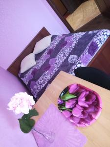 ヨシュカル・オラにあるKOMFORT около набережнойのベッド(花の盛り合わせが入ったテーブル付)