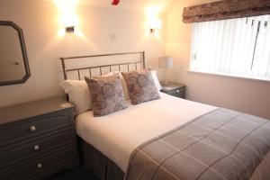 a bedroom with a bed with a dresser and a window at Berwick House in Sidmouth