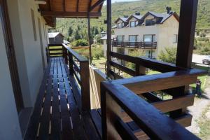 a balcony of a house with a wooden railing at Altos del Catedral in San Carlos de Bariloche