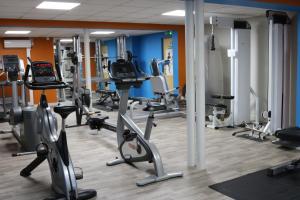 a gym with several treadmills and exercise bikes at The Heritage Park Hotel in Pontypridd