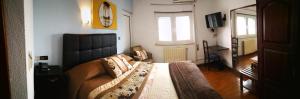 a bedroom with a large bed with a black headboard at Hotel 4 Estacoes in Chaves