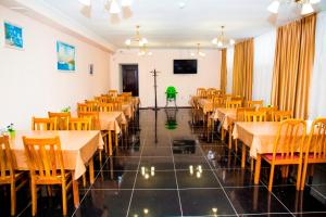 comedor con mesas y sillas y TV en Hotel Nurlytau en Borovoye