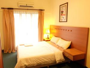 1 dormitorio con 1 cama grande y ventana en Marina Condominium Holiday Homestay, en Kota Kinabalu