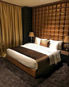 a bedroom with a large bed with a large headboard at Lumiere Des Etoile in Kuwait