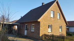 a brick house with a black roof at Haus Lotte in Garding