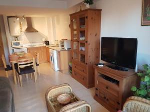 a living room with a flat screen tv on a wooden cabinet at APARTMENT LA ROTA - Benidormland in Cala de Finestrat